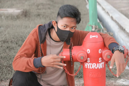 man in brown and black zip up jacket holding red water jug