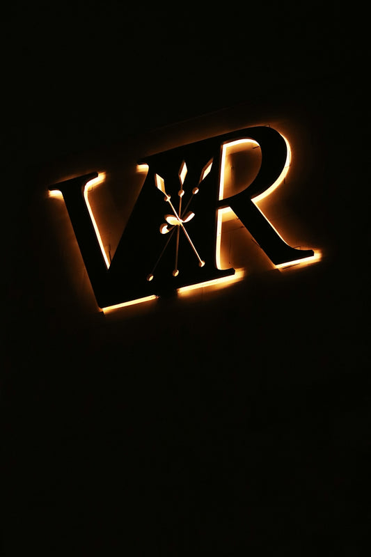 a lighted sign that reads vrr in a dark room