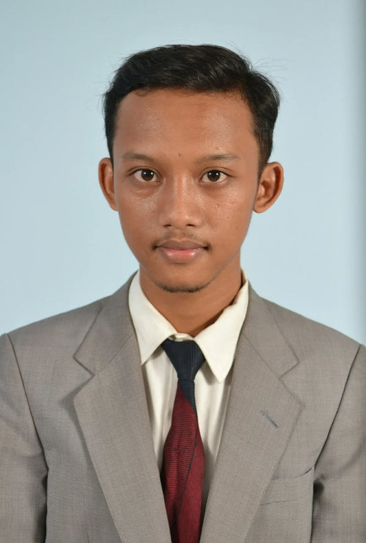 A young man in a formal suit poses for a portrait showcasing the best grill for camping and yachting