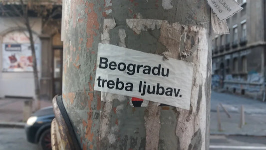a sticker on a tree in the middle of a street