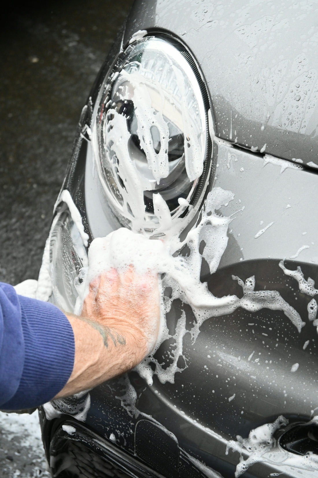 a person washing a car with a sponge