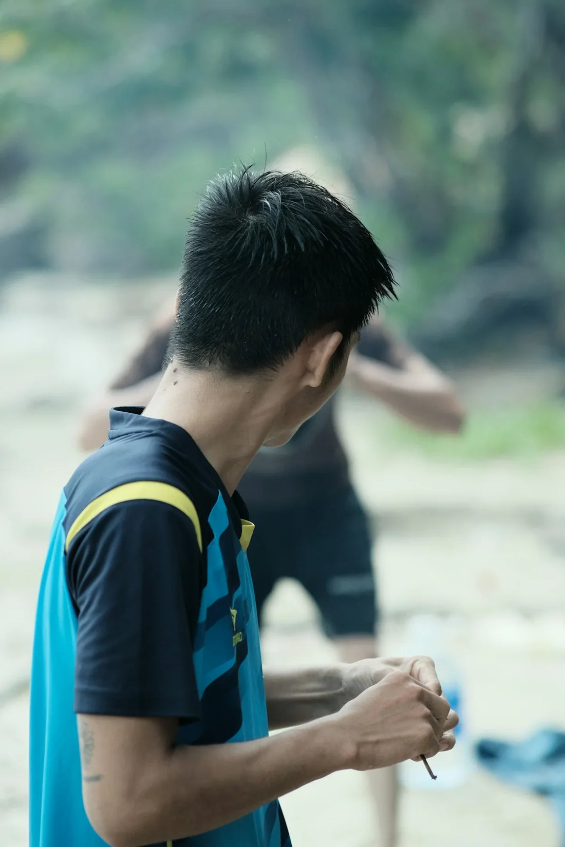 a man holding a frisbee while standing next to another man