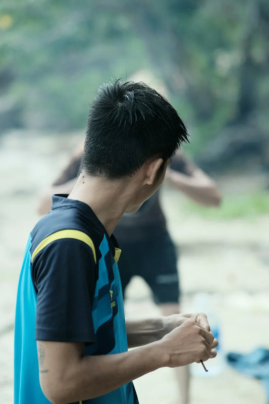 a man holding a frisbee while standing next to another man