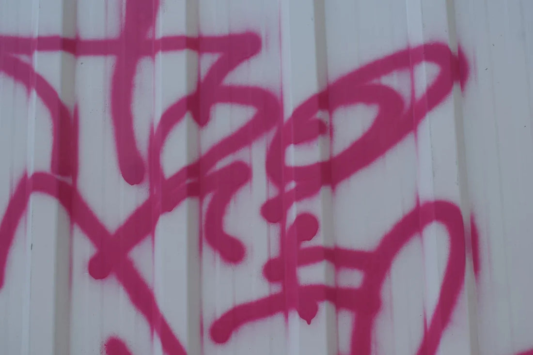 Pink graffiti on a white corrugated wall