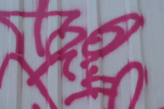 Pink graffiti on a white corrugated wall