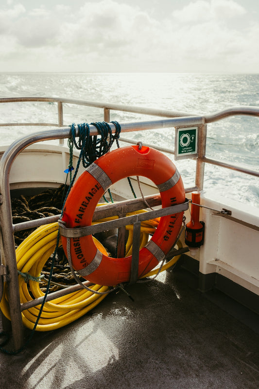 Orange life preserver and yellow rope on boat deck